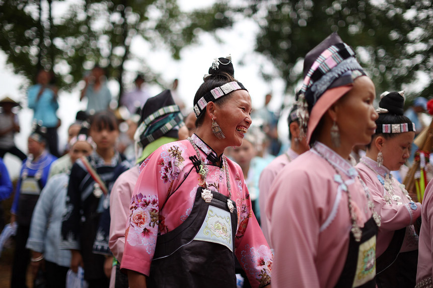 8月5日，盛裝打扮的苗族村民在山頂上跳蘆笙舞。