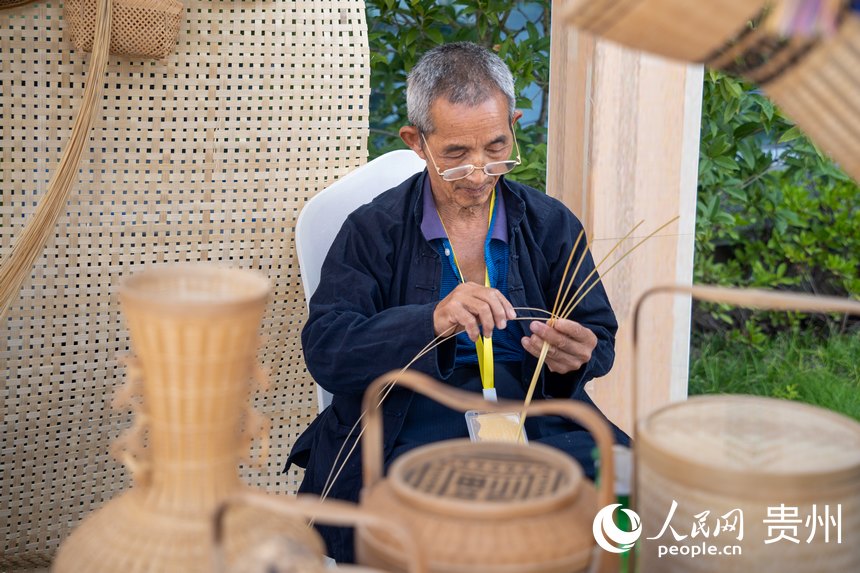 山地生活消費與非遺傳承展現場，非遺技藝三穗竹編傳承人展示竹編技藝。人民網 涂敏攝