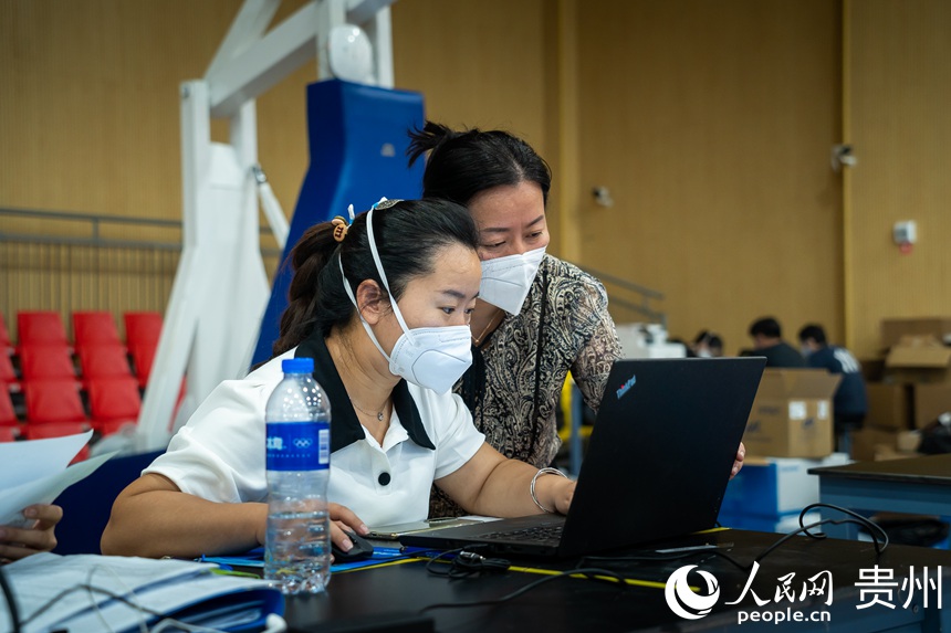 貴陽市第二人民醫院檢驗科主任袁軍（右）正與同事討論檢驗問題。人民網 涂敏攝