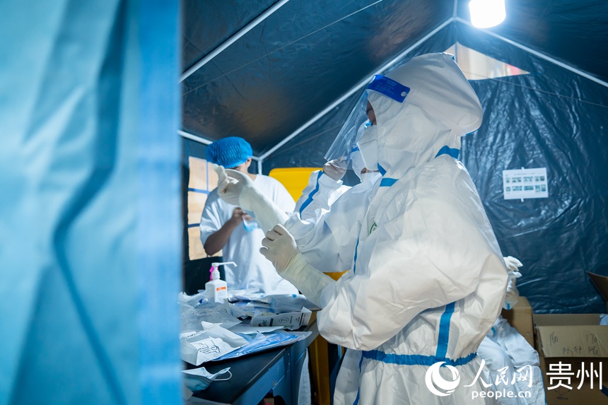 醫務人員正在穿防護服，之后將進入氣膜倉進行核酸檢驗。人民網 涂敏攝