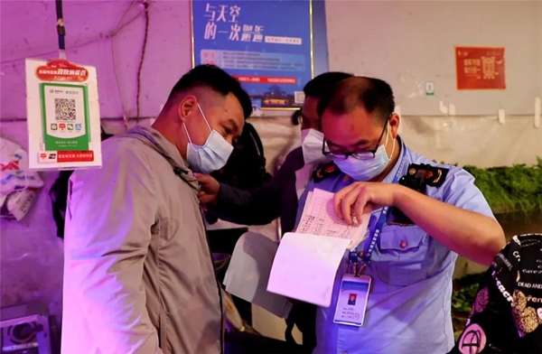 1 執法人員在碧潭園小區附近某生鮮店內查看相關單據。