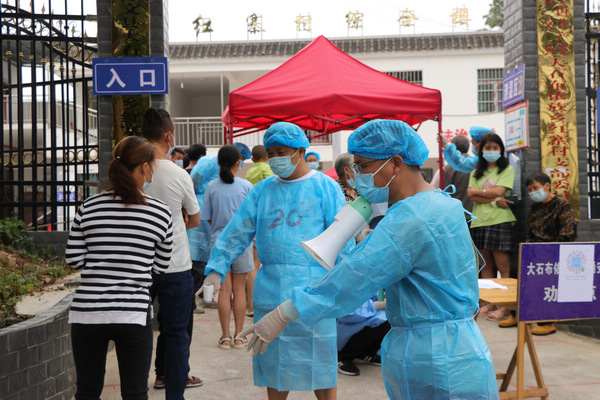 楊正文（右一）在核酸檢測現場維持秩序。鐘正超攝