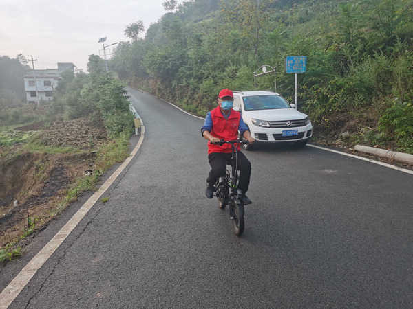 楊正文騎著電動自行車宣傳疫情防控。楊正文攝