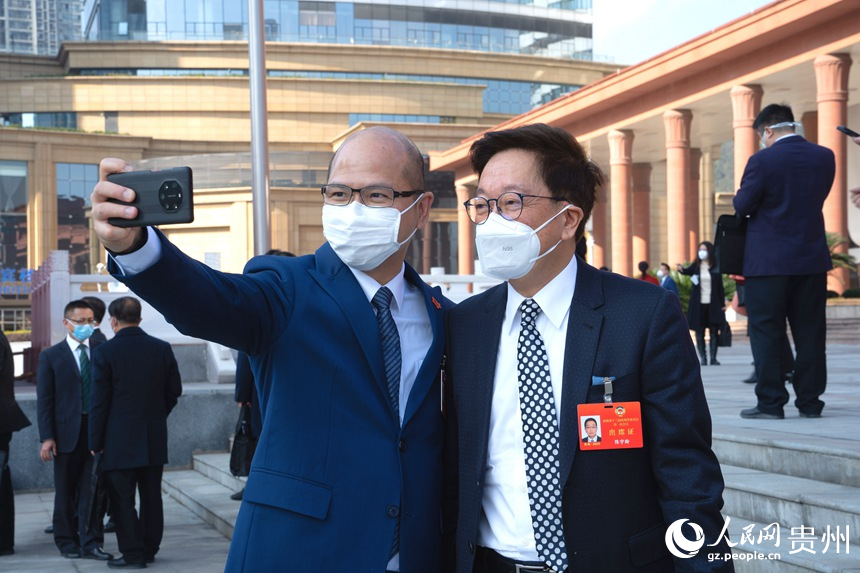 政協委員站在會議中心門口合影留念。人民網 陽茜攝