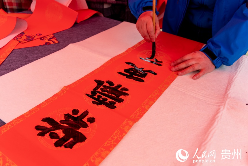 書法愛好者為村民書寫春聯。人民網 涂敏攝