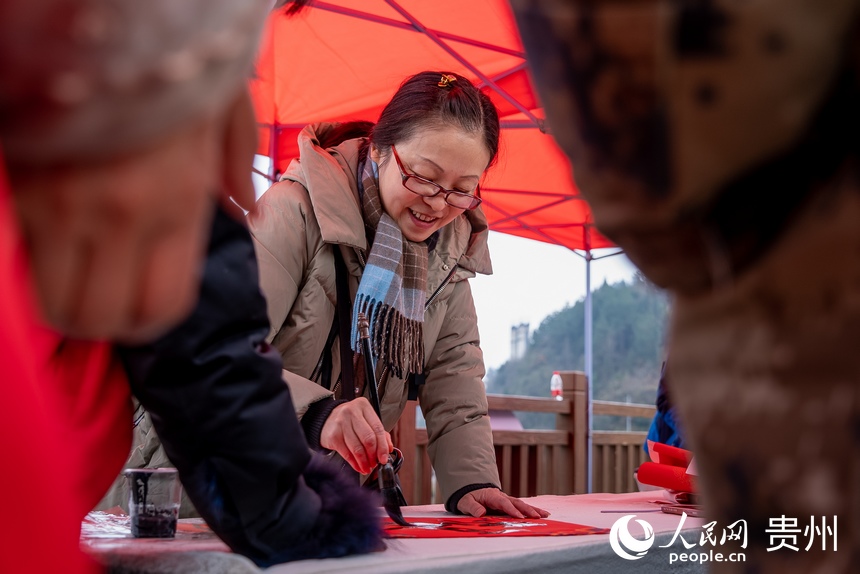 書法愛好者為村民書寫春聯。人民網 涂敏攝