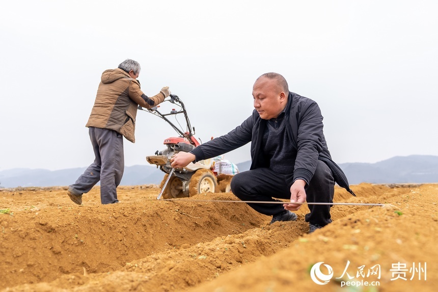 農業技術員查看村民起壟。人民網 涂敏攝