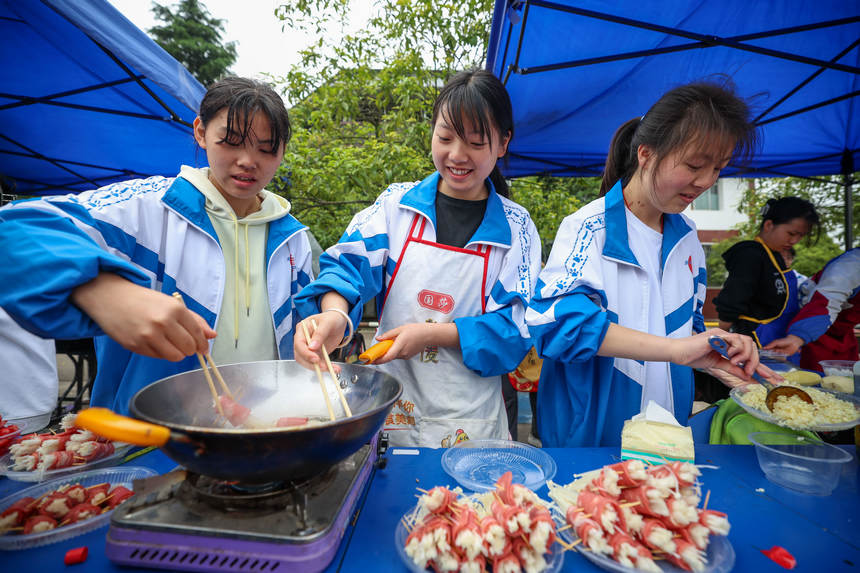 高三年級學生在“校園美食節”上烹飪美食。楊勝賢攝
