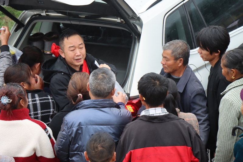 村民提著土特產前來送別莫書記。柏玉迪 攝