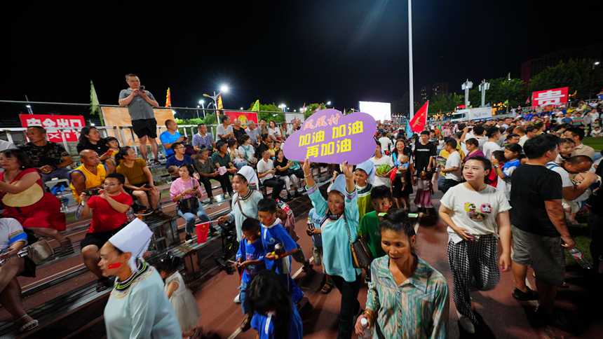 村民手舉加油牌為本村球員加油。周光勝攝