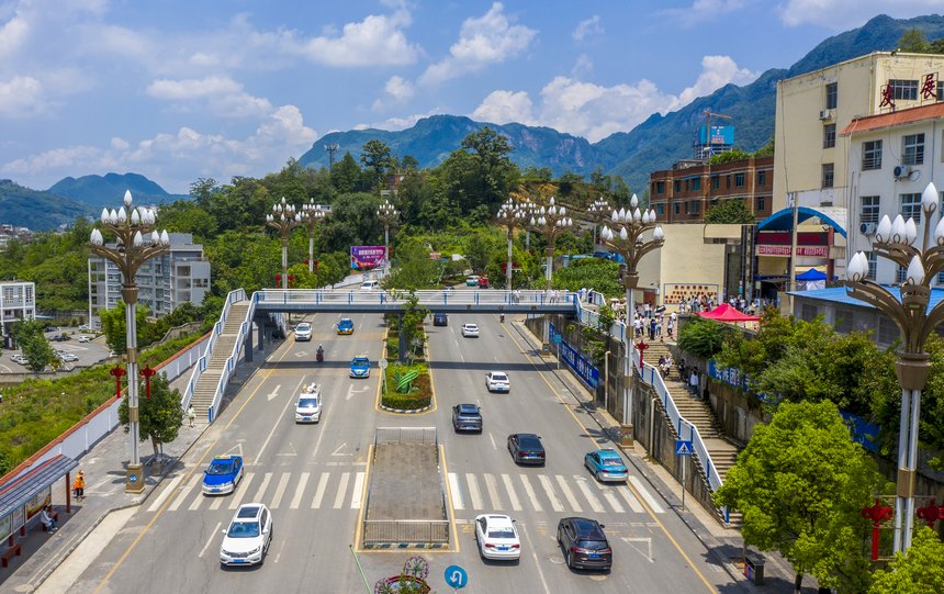 2023年6月25日，行人在赫章民族中學“同心”人行天橋上通行。