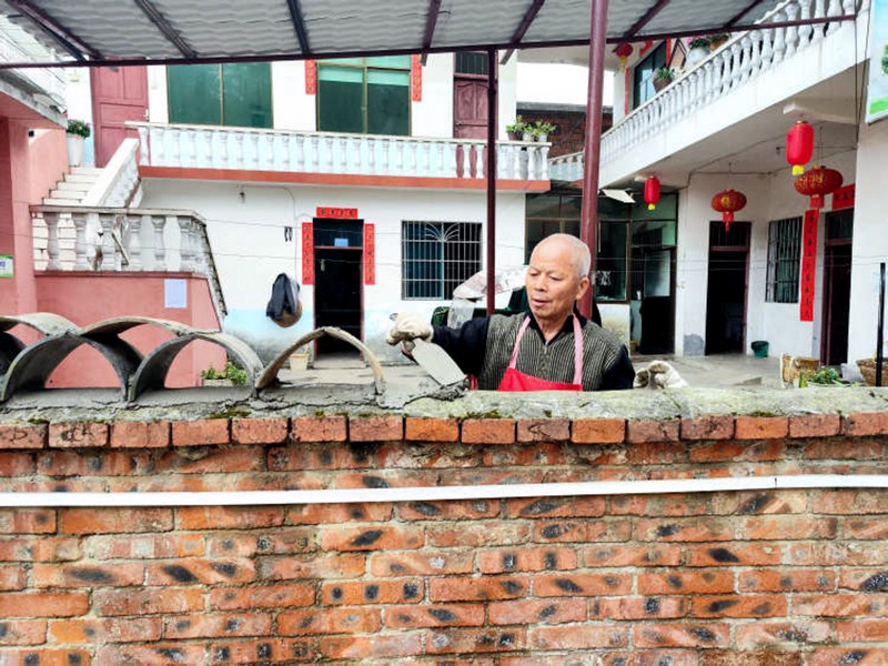 冠山街道三合社區老堡群眾正在用舊瓦片砌花式圍墻。龍里縣委宣傳部供圖