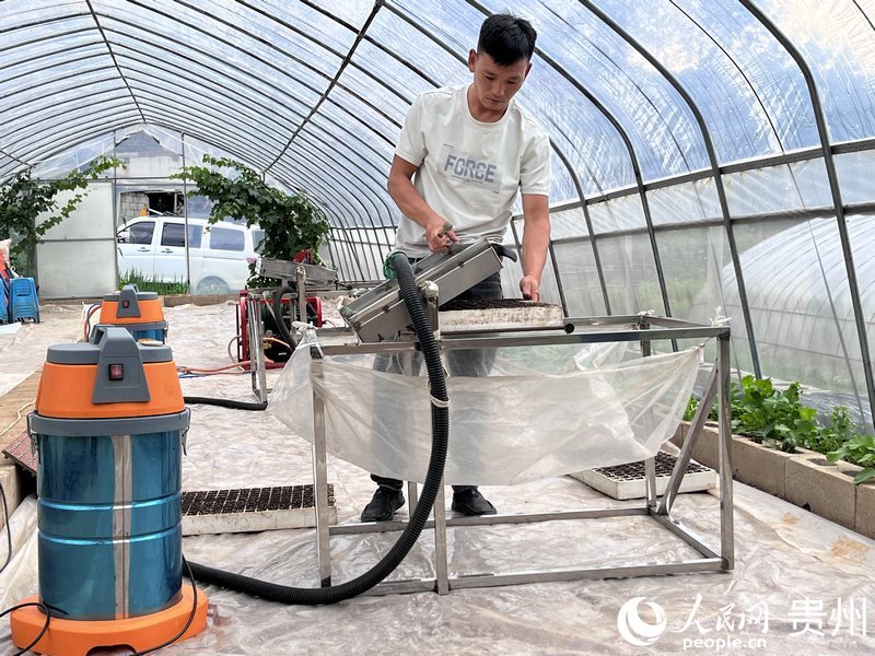 毛海龍正在演示“負壓式播種機”。人民網 陳潔泉攝.jpeg