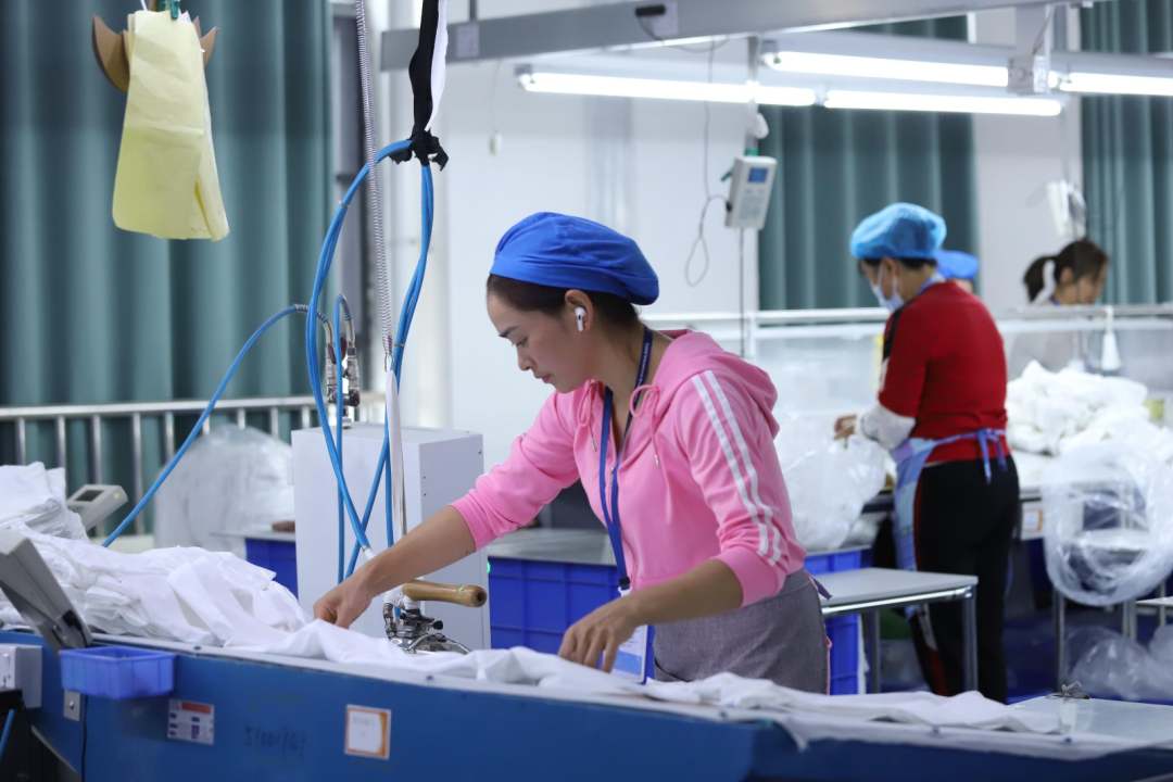  圖為工人熨燙衣物。