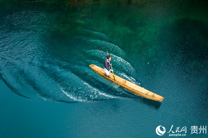 景區工作人員在臥龍潭上工作也成為一道美麗的風景。人民網記者 涂敏攝