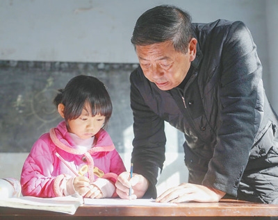 李明軍（右）在輔導學生做作業。