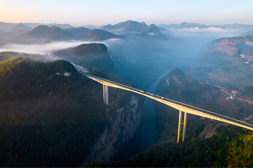 11月28日清晨，貴畢公路六廣河特大橋與云海、山川交相輝映，構成一幅壯美的交通畫卷。