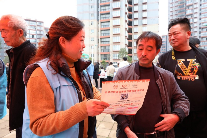 (4)2023年12月9日，清鎮市鄉愁社區云夢小鎮。圖為活動現場志愿者向小區居民宣傳普及信用知識。（任芳靚 攝）.jpg