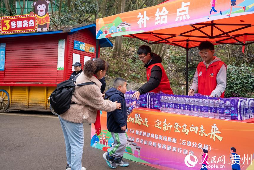 參與貴陽貴安第53屆全民健身登高迎新跑的市民領取補給。人民網記者 涂敏攝