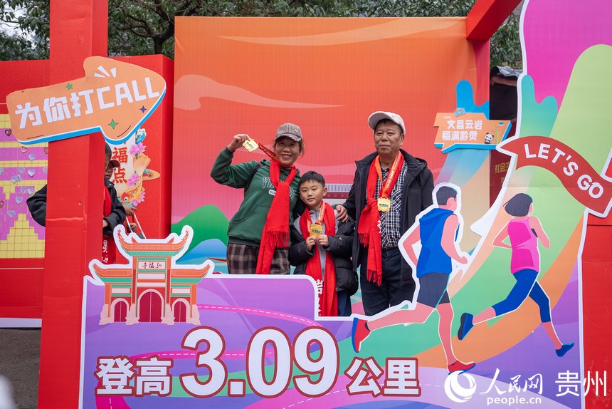參與貴陽貴安第53屆全民健身登高迎新跑的市民在終點打卡拍照。人民網記者 涂敏攝