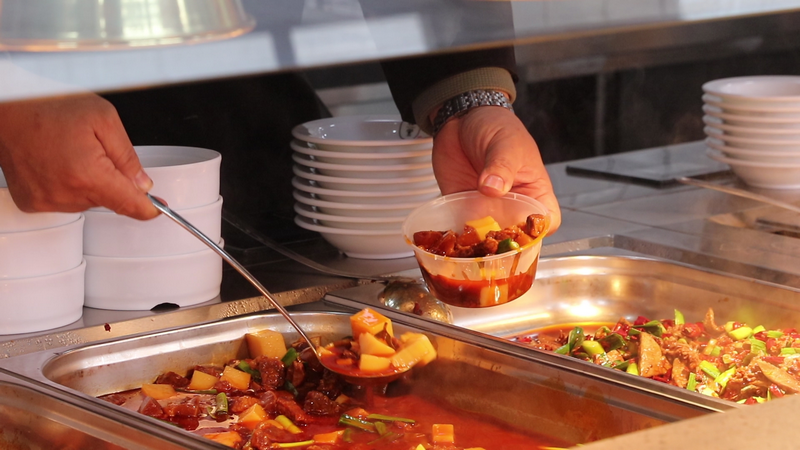 (4)食堂工作人員正在給顧客盛菜（王磊 攝）.bmp