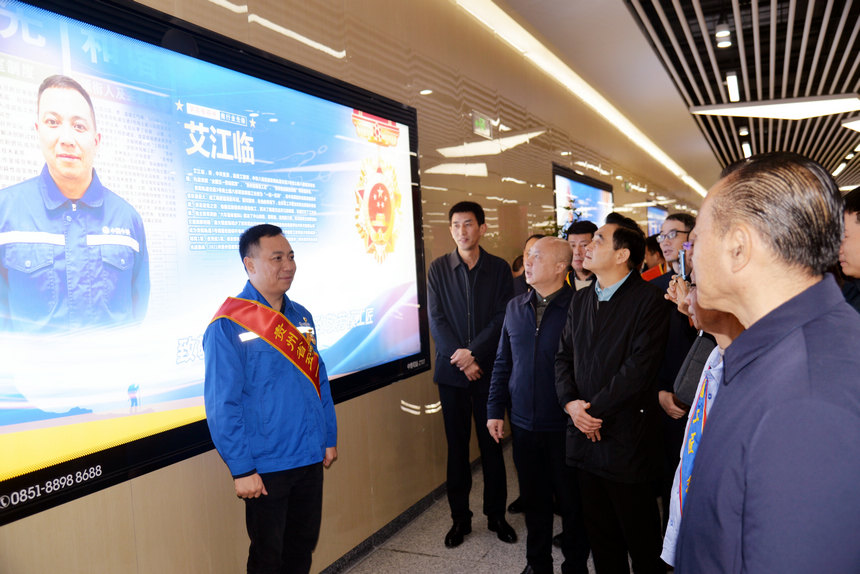 全國五一勞動獎章獲得者艾江臨與自己的宣傳海報合影。圖片由貴州省總工會提供