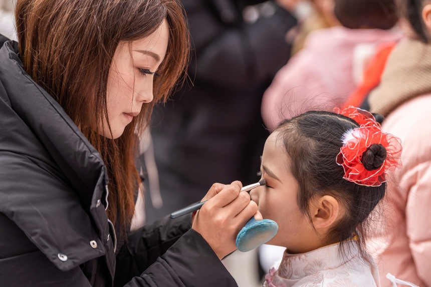 社區居民在給即將上臺表演的小朋友化妝。羅大富攝