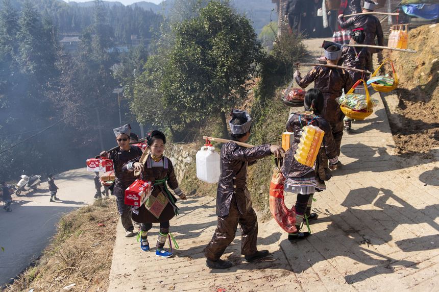 2024年2月11日，在貴州省從江縣丙妹鎮兩料村，來自大塘村的苗族舅舅在給外甥女“送年粑”。