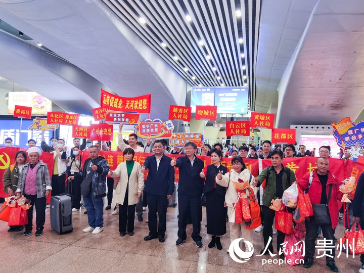 到達廣州后，返崗務工人員代表與黔粵兩地人社部門相關負責人合影留念。人民網 王秀芳攝