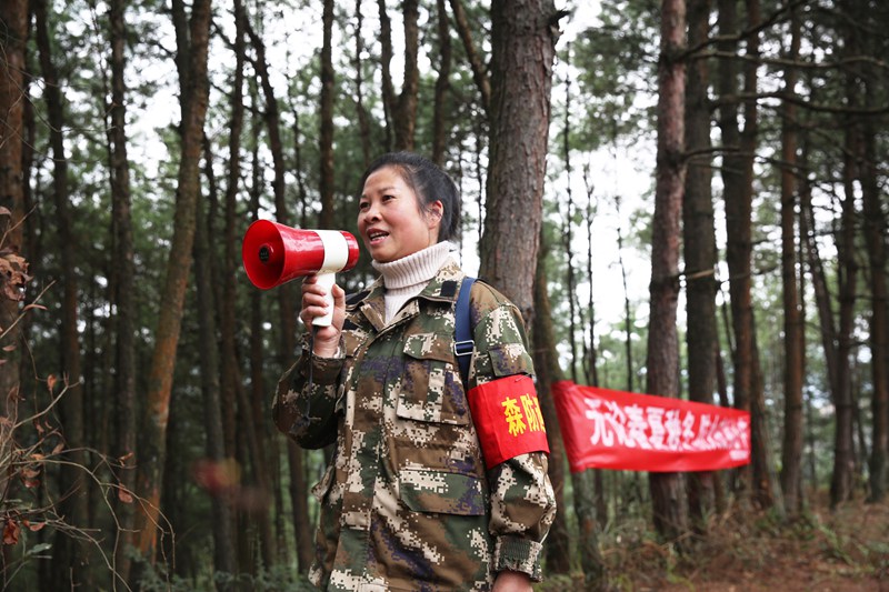 錦屏縣國有林場女子護林隊員向進入林區人員喊話、宣傳森林防火知識。