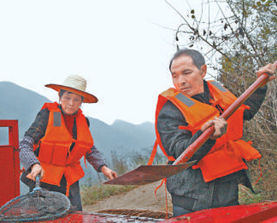 盧錫永（右）、冉戌英夫婦在清理打撈上岸的雜物。龍章榆攝