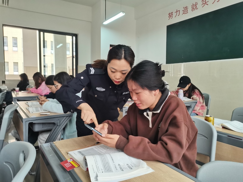 民警指導學生下載“國家反詐中心”APP。