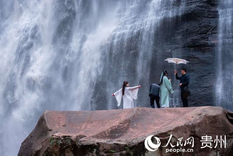 游客在赤水大瀑布前打卡拍照。人民網記者 涂敏攝