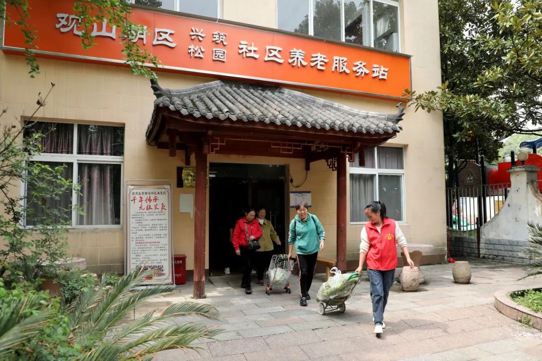 站點工作人員幫助老人送菜。