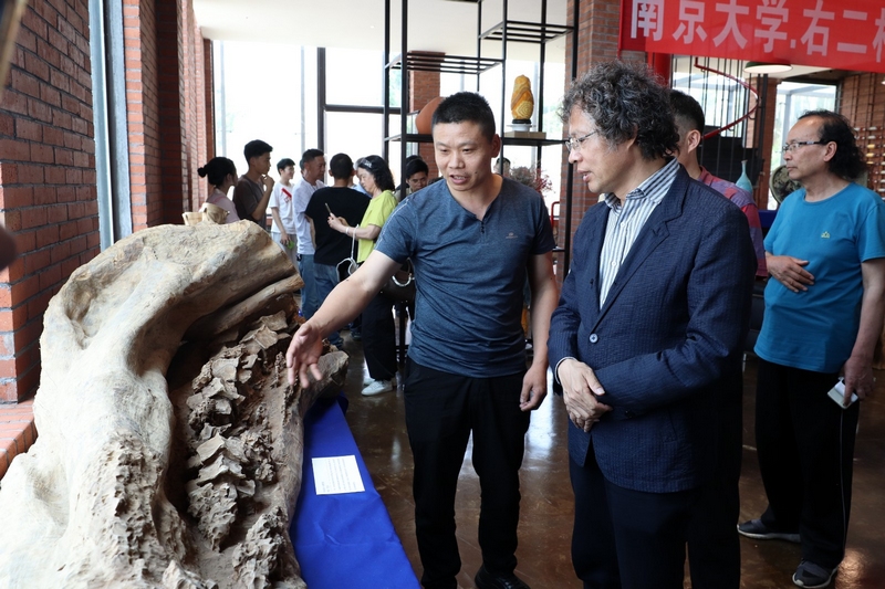 “兵工匠”劉吉武（左一）介紹其雕刻的工藝作品。