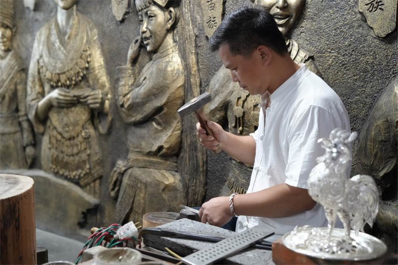 雷山苗族銀匠正專注于鍛制精美的銀飾作品。姚晶權攝