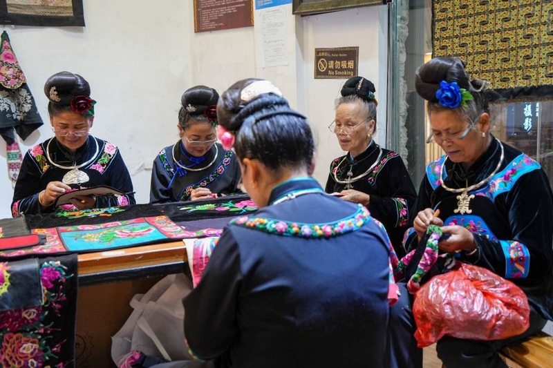 身穿苗族服飾的繡娘們圍坐在一起，手中針線翻飛，一幅幅精美的苗繡圖案在她們的巧手下逐漸成形。姚晶權攝