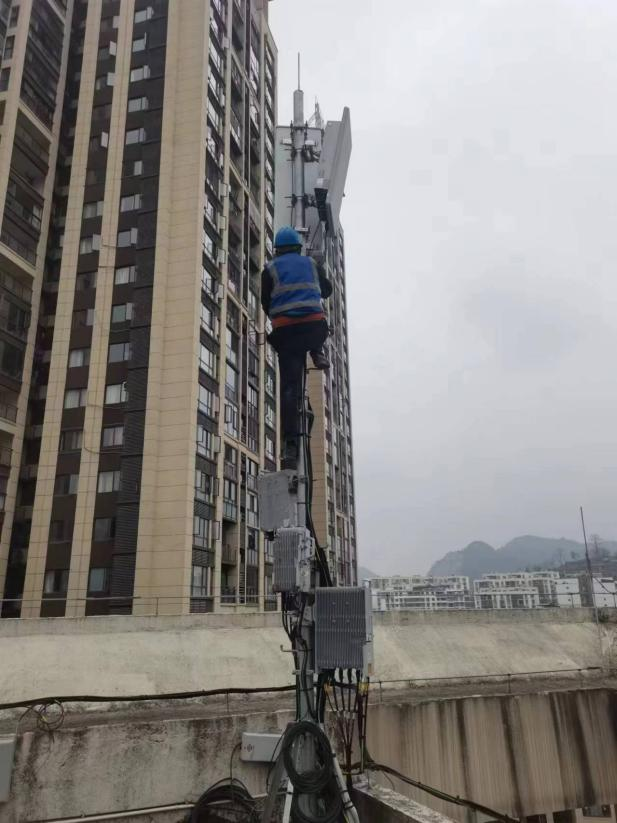 圖為移動公司工作人員為小區住宅安裝移動網絡設備。