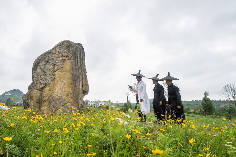 2024年7月5日，在貴州省畢節市百里杜鵑管理區方家坪景區，黃承龍帶著兩名副祭司正在進行祭祀活動的前期場地準備工作。