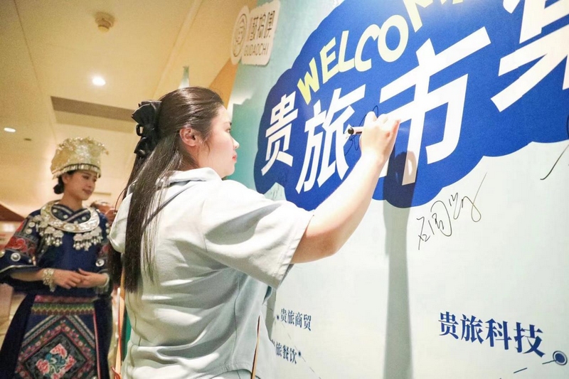 參會嘉賓在打卡墻前簽字留念。