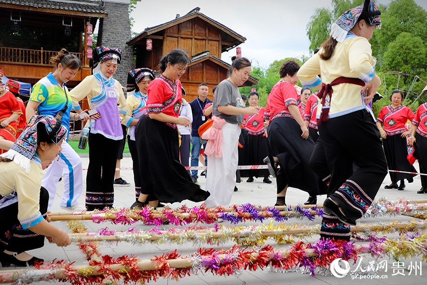 當地當地群眾邀請游客參與跳竹竿。人民網 龍章榆攝