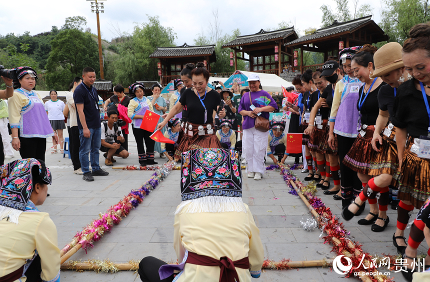 當地群眾邀請游客參與跳竹竿。人民網 龍章榆攝