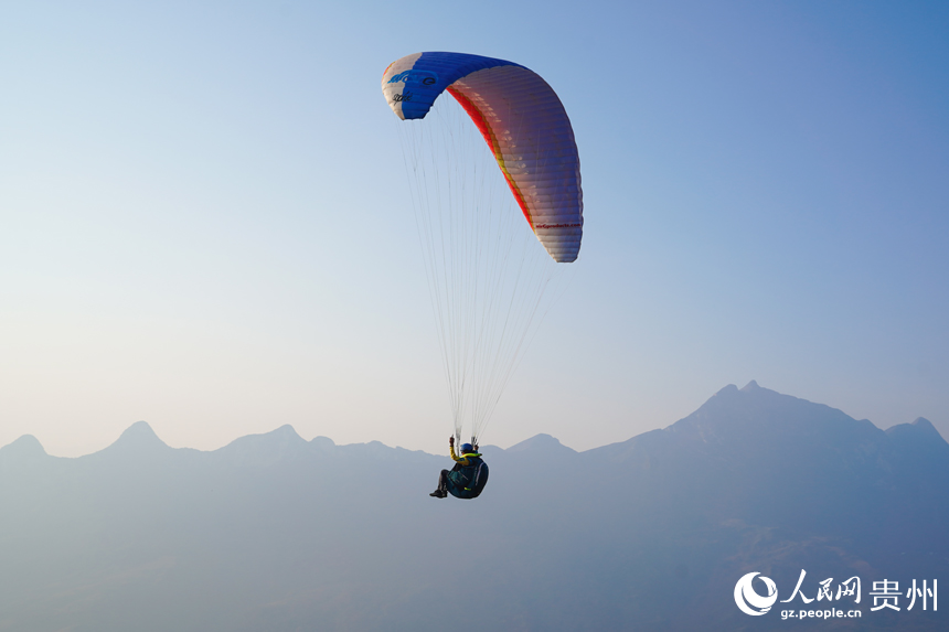 翱翔在牂牁江上空的滑翔傘運動員。人民網記者 涂敏攝