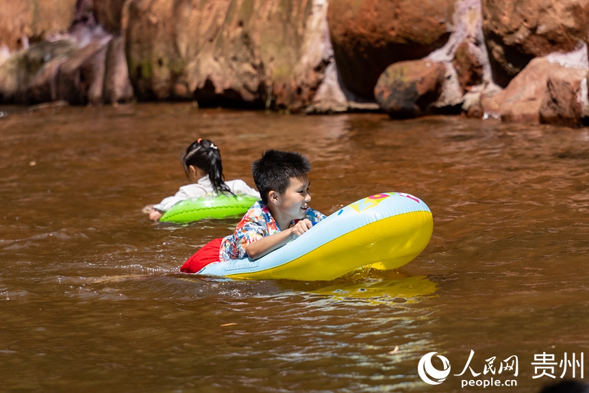 在瑪瑙灘內戲水的小朋友。人民網記者 涂敏攝