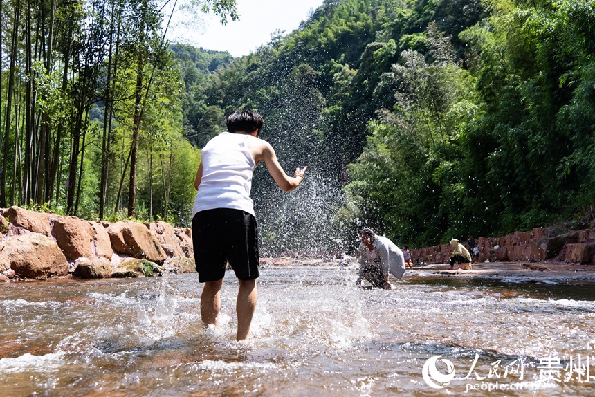游客在瑪瑙灘內打水仗。人民網記者 涂敏攝