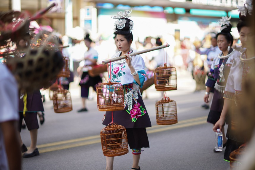 7月21日，貴州省丹寨縣身著傳統盛裝服飾的群眾，在展示非遺項目鳥籠制作技藝作品。