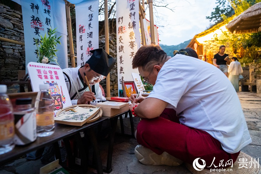 游客在屯堡內書寫?？?。人民網記者 涂敏攝