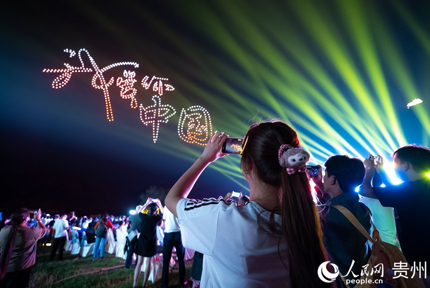 游客在云峰屯堡內觀看無人機燈光秀。人民網記者 涂敏攝