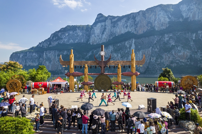 貴州省黔西市烏江源百里畫廊化屋景區，游客觀賞當地苗族村民表演原生態歌舞（無人機照片）。