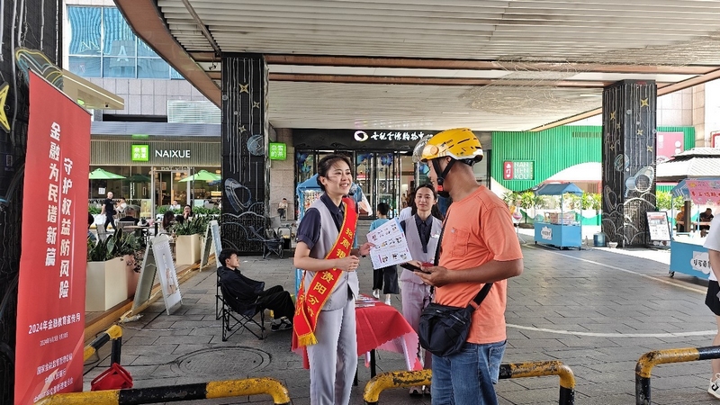 工作人員向游客講解反假貨幣金融知識。招商銀行貴陽支行供圖